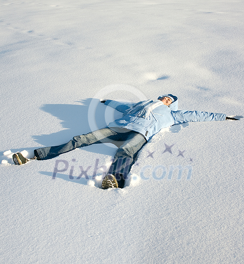 Happy young girl lying in the snow Happy young girl lying in the snow
