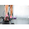 Young woman's muscular legs on stepper/treadmill, closeup