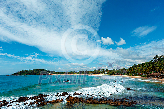Mirissa beach in Sri Lanka in daytime with clouds and waves in sea Mirissa beach in Sri Lanka in daytime with clouds and waves in sea