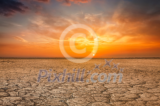 Global worming concept - cracked scorched earth soil drought desert landscape dramatic sunset Global worming concept - cracked scorched earth soil drought desert landscape dramatic sunset