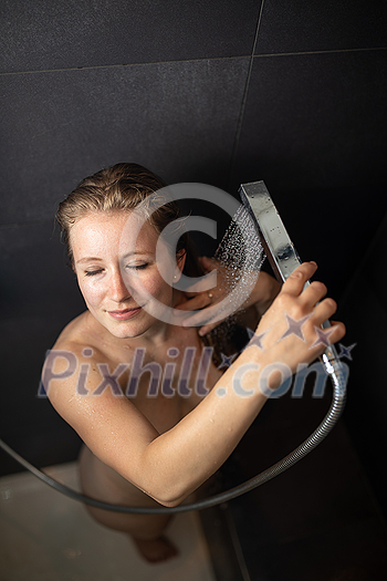 Pretty,young woman taking a long hot shower in a modern bathroom Pretty,young woman taking a long hot shower in a modern bathroom