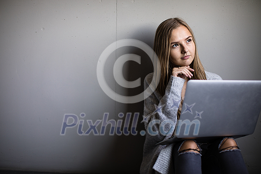 Pretty, young woman with her laptop studying for an exam/working Pretty, young woman with her laptop studying for an exam/working