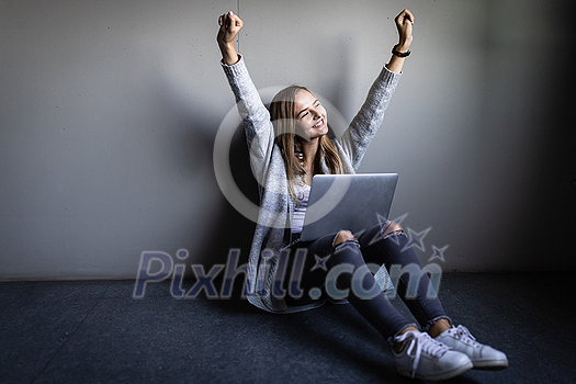 Pretty, young woman with her laptop happy about a studying/work achievement Pretty, young woman with her laptop happy about a studying/work achievement