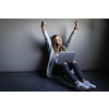 Pretty, young woman with her laptop happy about a studying/work achievement