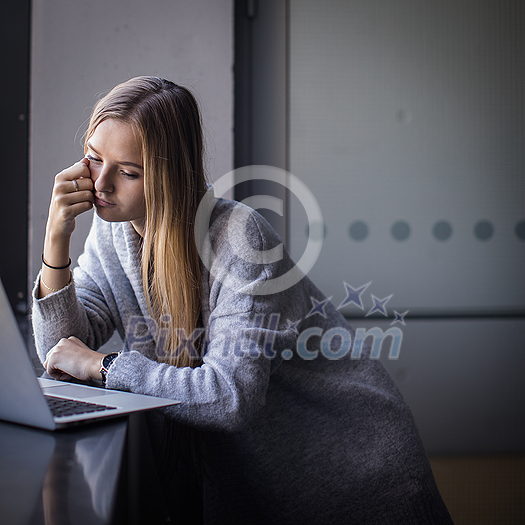 Pretty, young woman with her laptop studying for an exam/working Pretty, young woman with her laptop studying for an exam/working
