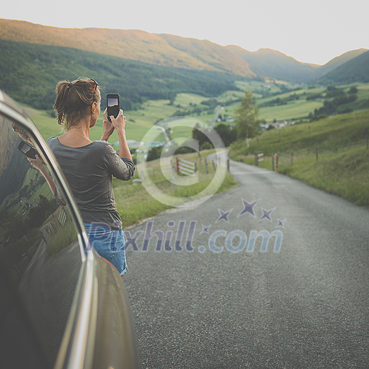 Traveling in nature, woman photographing alpine landscape with her smartphone Traveling in nature, woman photographing alpine landscape with her smartphone