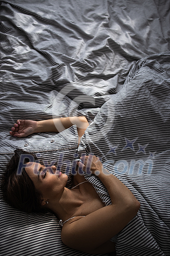 Pretty, young woman in her bed, fast asleep. Importance of sleep concept