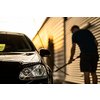 Young man washing his beloved car carefully in a manual car wash to prevent any damage and detail it properly