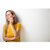 Mid-aged woman touching her cheek/mouth with painful expression because of toothache/dental issue