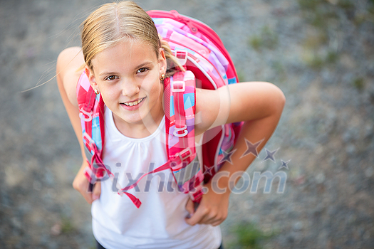 Cute little girl going home from school, looking well before crossing the street Cute little girl going home from school, looking well before crossing the street