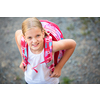 Cute little girl going home from school, looking well before crossing the street