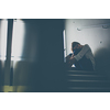 Depressed young woman sitting in a staircase, jobloss due to coronavirus pandemic, Covid-19 outbreak. Unemployment, economic crisis, financial distress concept