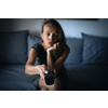 Pretty, young woman sitting on the sofa indoors at home and watching TV