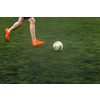 Fast moving feet of a soccer player on a pitch during a match (panned image with motion bliur)