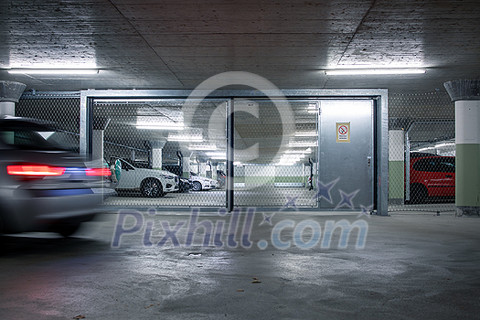 Underground parking. Cars parked in a garage with no people. Many cars in parking garage interior. Underground parking with cars (color toned image) Underground parking. Cars parked in a garage with no people. Many cars in parking garage interior. Underground parking with cars (color toned image)