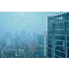 Rain water drops droplets on window glass texture with skyscrapers in background