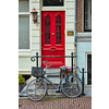 Bicycle near door of old house in Amsterdam street. Bicycles are the very popular means of transport in Netherlands. Amsterdam, Netherlands