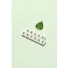 Green energy words formed of scrabble tiles with fresh tree leaf on light green background. Eco energy and natural resource conservation concept.