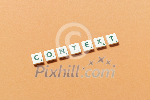 Context word formed of scrabble tiles on orange background. Original web template design in pastel color. Context word formed of scrabble tiles on orange background. Original web template design in pastel color.