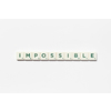 Impossible word formed of scrabble tiles on white background. Simple creative backdrop for business presentation.