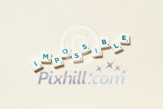 Impossible word formed of scrabble tiles on beige background. Simple creative backdrop for business presentation. Impossible word formed of scrabble tiles on beige background. Simple creative backdrop for business presentation.
