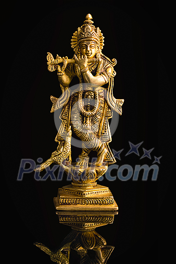 Krishna god Vishnu avatar brass statue isolated on black with reflection Krishna god Vishnu avatar brass statue isolated on black with reflection