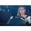Pretty midle aged woman at the steering wheel of her car, going fast