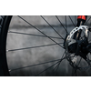 Hydraulic bicycle disk brakes, grey metal disc attached to bike wheel close up, effective popular mountain bicycle brakes. Hydraulic disk brakes on bicycle wheel, bicycle spokes gray background