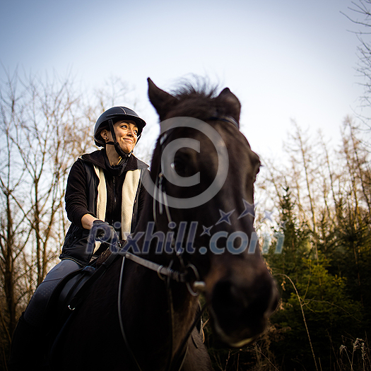 Female horse rider riding outdoors on her lovely horse Female horse rider riding outdoors on her lovely horse
