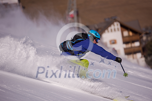 young athlete freestyle Skier having fun while running downhill in beautiful Alpine landscape on sunny day during winter season