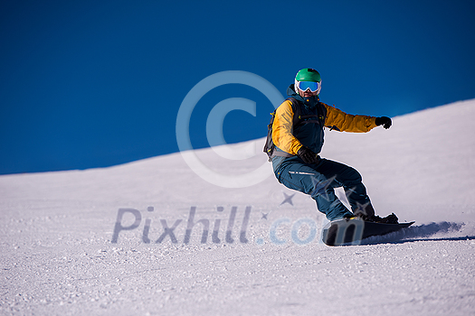 Young freestyle snowboarder running down the slope and ride free style at sunny winter day on Alpine mountains. Winter sport and recreation, leisure outdoor activities. Young freestyle snowboarder running down the slope and ride free style at sunny winter day on Alpine mountains. Winter sport and recreation, leisure outdoor activities.