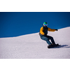 Young freestyle snowboarder running down the slope and ride free style at sunny winter day on Alpine mountains. Winter sport and recreation, leisure outdoor activities.