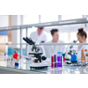 Microscope on the workplace near test tubes with different liquid. Healthcare and biotechnology concept
