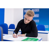 young male student writing notes in the classroom