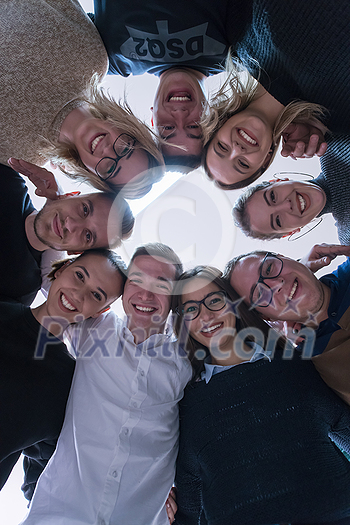 Group of young students in electronics classroom celebrating successfully finished project with holding their hands together, education and technology concept