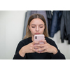 young female student using a mobile phone during the break in the classroom