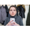 young female student using a mobile phone during the break in the classroom