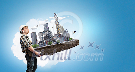 Engineer man holding construction model in hands. Mixed media Engineer man holding construction model in hands. Mixed media