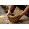 Pottery - skilled wet hands of potter shaping the clay on potter wheel. Pot, vase throwing. Manufacturing traditional handicraft Indian bowl, jar, pot, jug. Shilpagram, Udaipur, Rajasthan, India