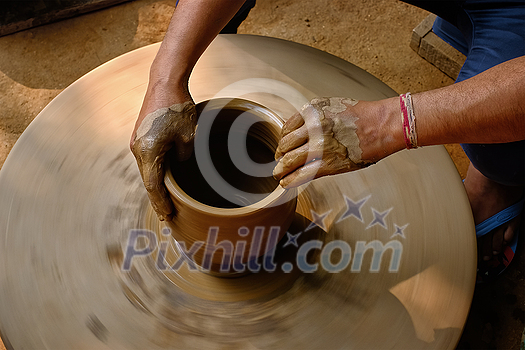 Pottery - skilled wet hands of potter shaping the clay on potter wheel. Pot, vase throwing. Manufacturing traditional handicraft Indian bowl, jar, pot, jug. Shilpagram, Udaipur, Rajasthan, India Pottery - skilled wet hands of potter shaping the clay on potter wheel. Pot, vase throwing. Manufacturing traditional handicraft Indian bowl, jar, pot, jug. Shilpagram, Udaipur, Rajasthan, India