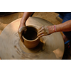 Pottery - skilled wet hands of potter shaping the clay on potter wheel. Pot, vase throwing. Manufacturing traditional handicraft Indian bowl, jar, pot, jug. Shilpagram, Udaipur, Rajasthan, India