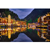 Chinese tourist attraction destination - Feng Huang Ancient Town (Phoenix Ancient Town) on Tuo Jiang River illuminated at night. Hunan Province, China