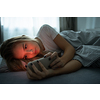 Pretty, young woman sleeping in her bed with her cell phone close to her. Smartphone in Bed Mobile/smartphone  Addiction Concept.
