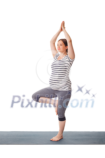 Pregnancy yoga exercise - pregnant woman doing asana Vrikshasana - tree pose isolated on white background