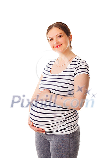 Pregnant smiling woman standing on yoga mat embracing her belly isolated on white background Pregnant smiling woman standing on yoga mat embracing her belly isolated on white background