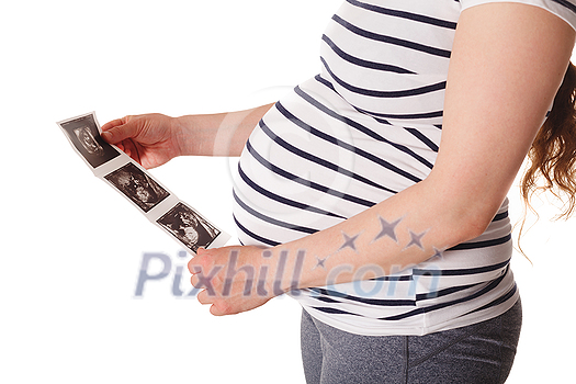 Pregnant woman standing and holding her ultrasound baby scan picture isolated on white Pregnant woman standing and holding her ultrasound baby scan picture isolated on white