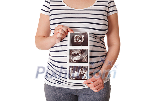 Pregnant woman standing and holding her ultrasound baby scan picture isolated on white Pregnant woman standing and holding her ultrasound baby scan picture isolated on white