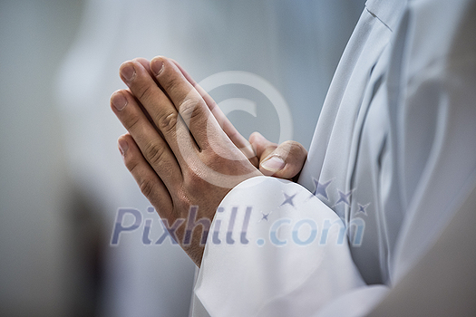 Hands of a priest consecrating a host as the body of Christ to distribute it to the communicants in the church Hands of a priest consecrating a host as the body of Christ to distribute it to the communicants in the church
