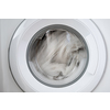 Close-up laundry running washing machine at home, amid a washing cycle, home electronics concept