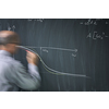 Math teacher drawing   fuction graph on a blackboard during mathclass (motion blurred image)